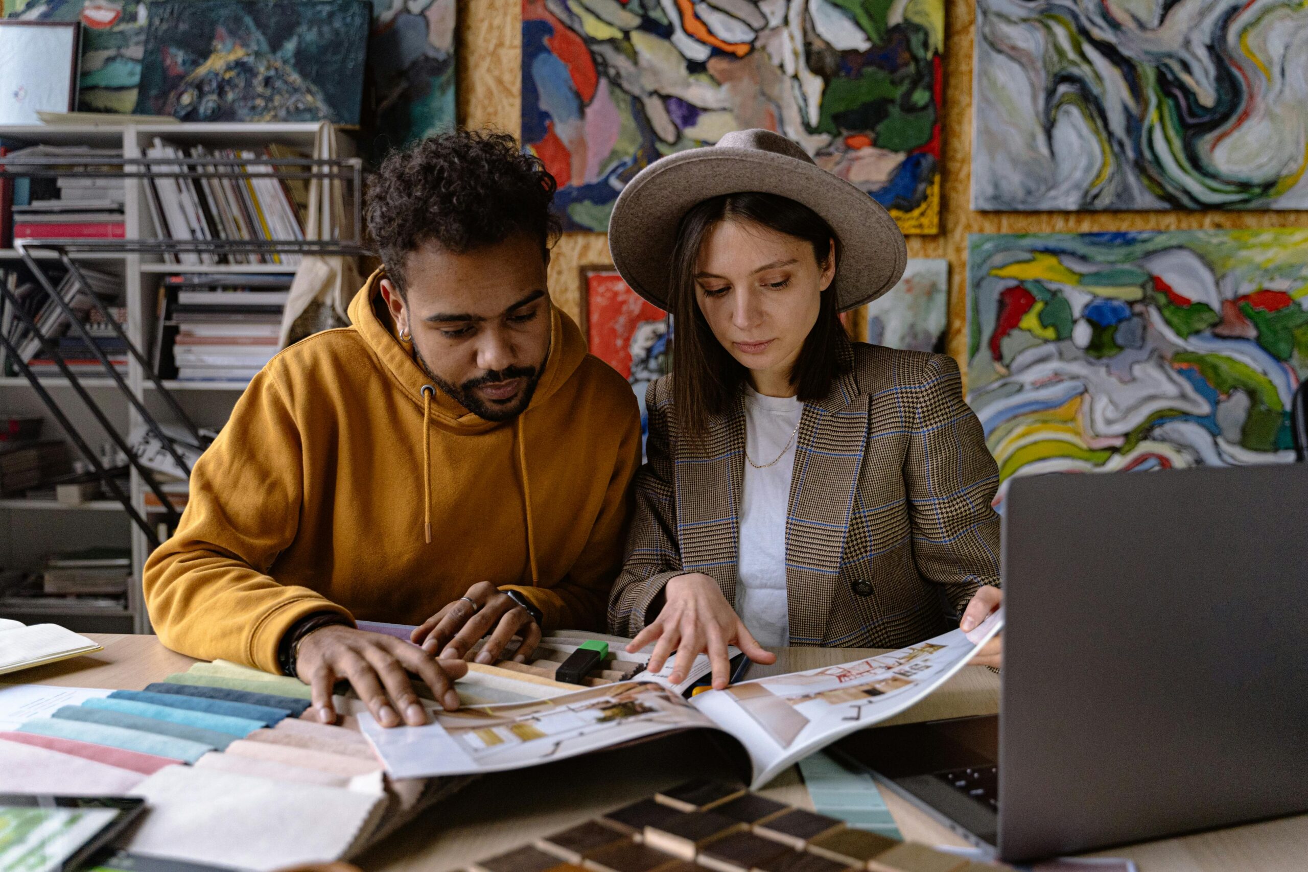 Two designers analyzing design projects together in a vibrant creative space.